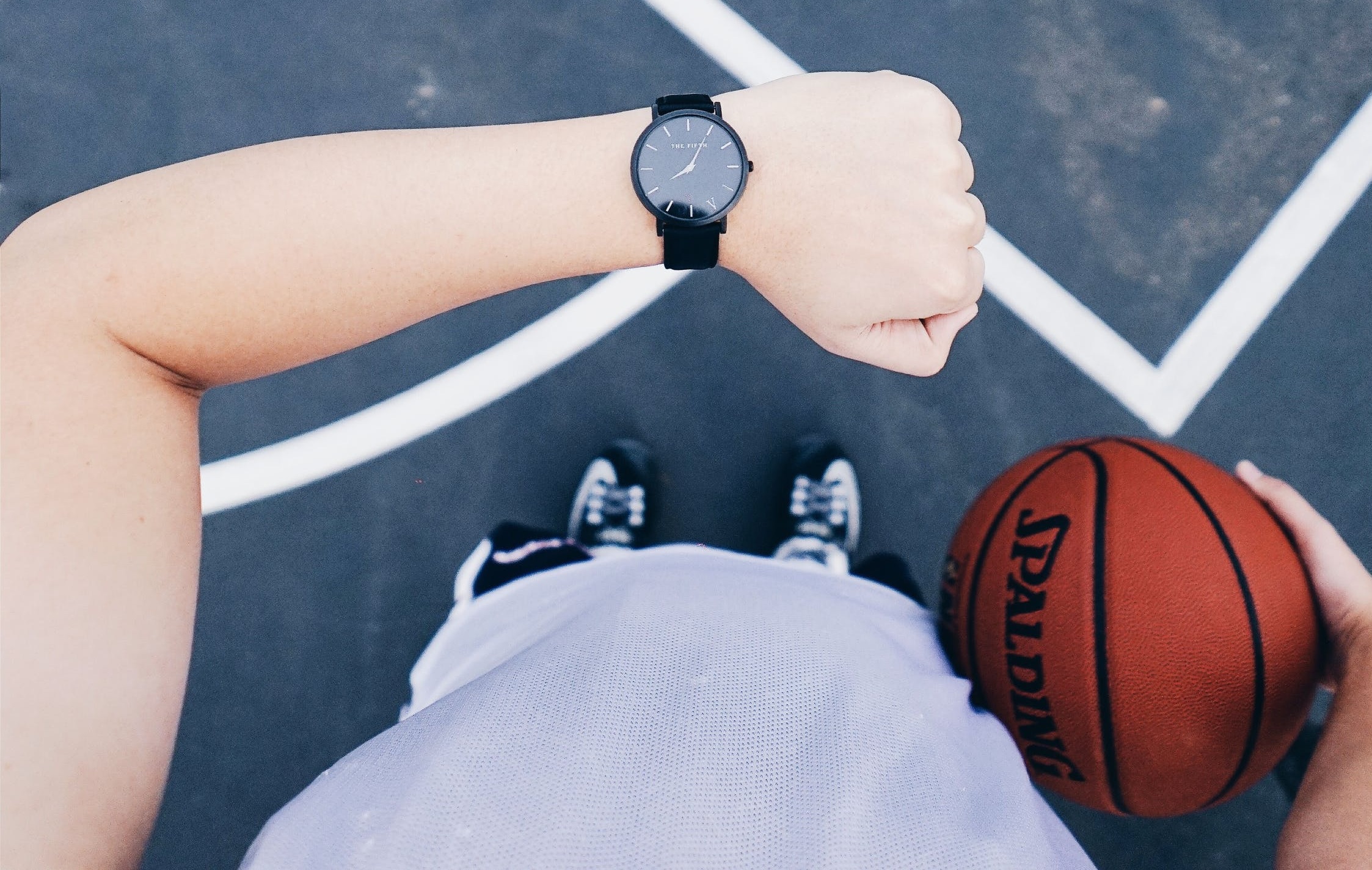 Jeune homme qui porte une montre de sport pour jouer au basket